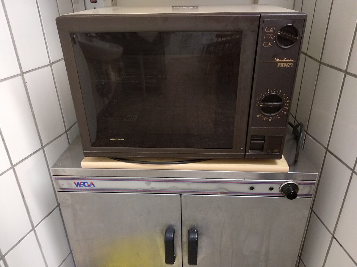Mikrowelle auf dem Tellerwärmer-Schrank