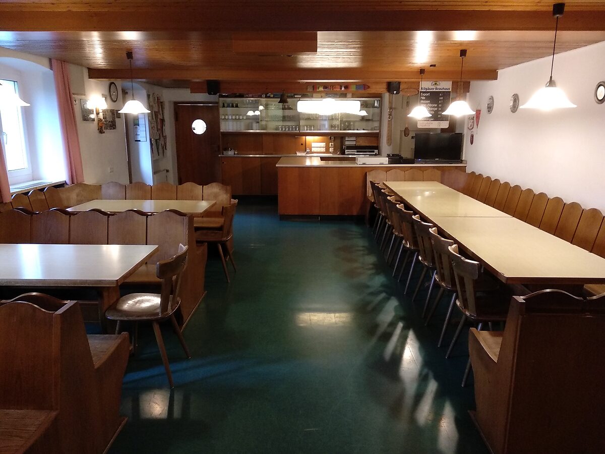 Speisesaal mit langen Tischen und Ausgabetheke