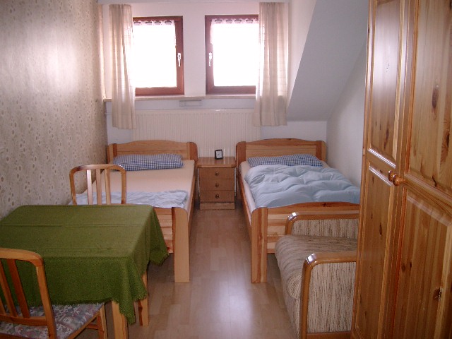 Begleiterzimmer mit zwei Einzelbetten, Tisch und Kleiderschrank