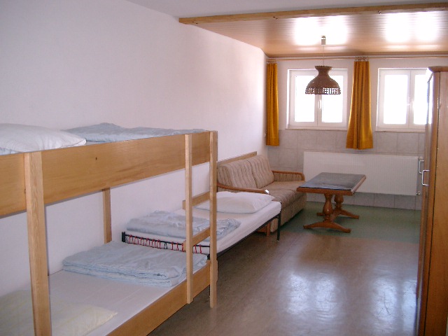 Schülerzimmer mit Etagenbett, Schlafcouch und Tisch