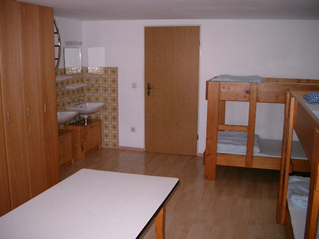 Schülerzimmer mit Etagenbett, Waschbecken und Kleiderschrank